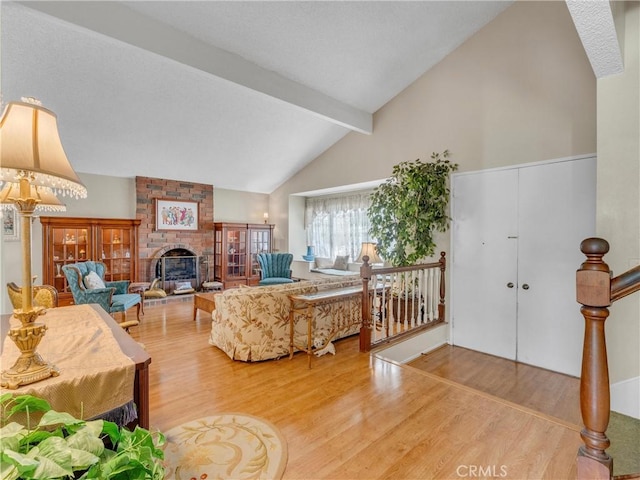 23403 Via Castanet, Valencia, CA 91355 - living area featuring wood finished floors, beamed ceiling, a fireplace, and high vaulted ceiling