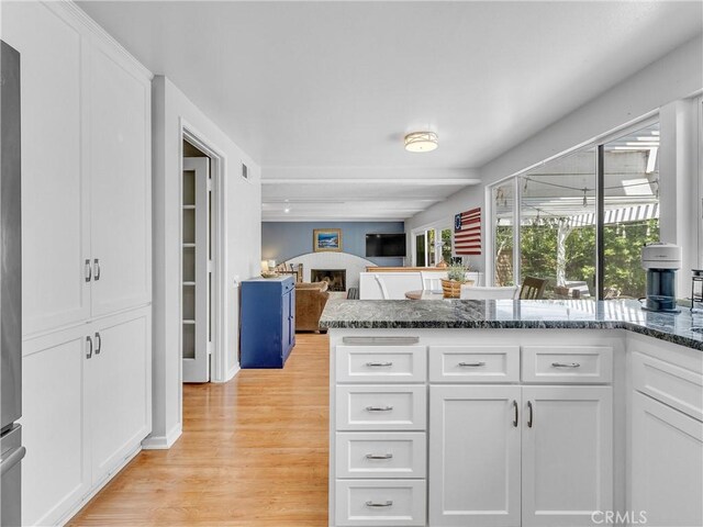 23403 Via Castanet, Valencia, CA 91355 - kitchen featuring white cabinets, light wood finished floors, dark stone countertops, and open floor plan