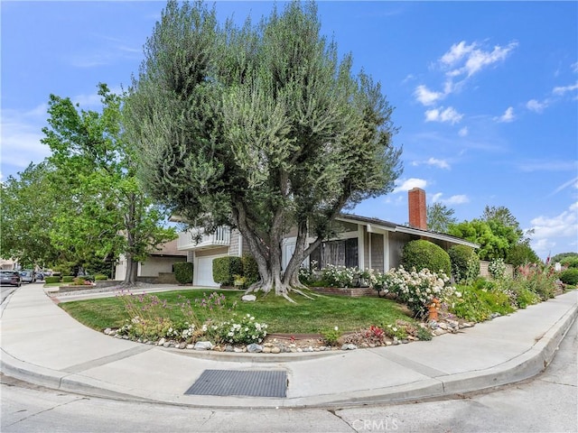 23403 Via Castanet, Valencia, CA 91355 - view of front of house with a front yard, concrete driveway, a chimney, and an attached garage