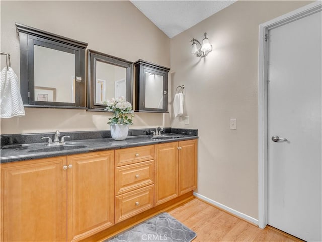 23403 Via Castanet, Valencia, CA 91355 - bathroom featuring double vanity, wood finished floors, baseboards, and lofted ceiling