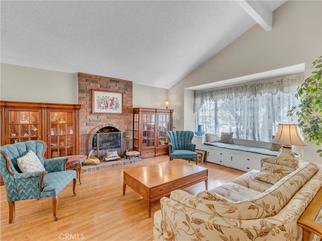 23403 Via Castanet, Valencia, CA 91355 - living room featuring wood finished floors, beamed ceiling, a textured ceiling, a brick fireplace, and high vaulted ceiling