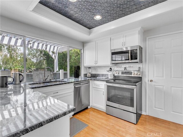 23403 Via Castanet, Valencia, CA 91355 - kitchen featuring appliances with stainless steel finishes, a sink, white cabinetry, ornamental molding, and backsplash
