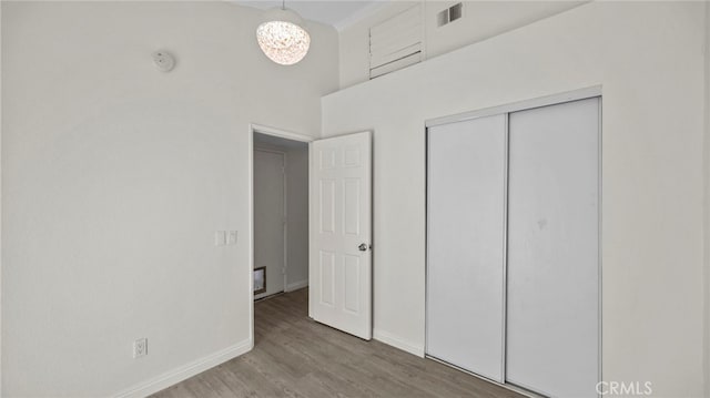 10133 Shinon Dr, Rancho Cucamonga, CA 91737 - unfurnished bedroom with wood finished floors, baseboards, a towering ceiling, and a closet