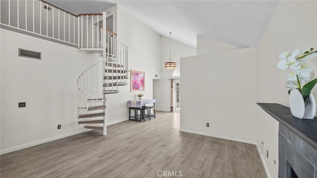 10133 Shinon Dr, Rancho Cucamonga, CA 91737 - living room featuring high vaulted ceiling, wood finished floors, stairway, and baseboards