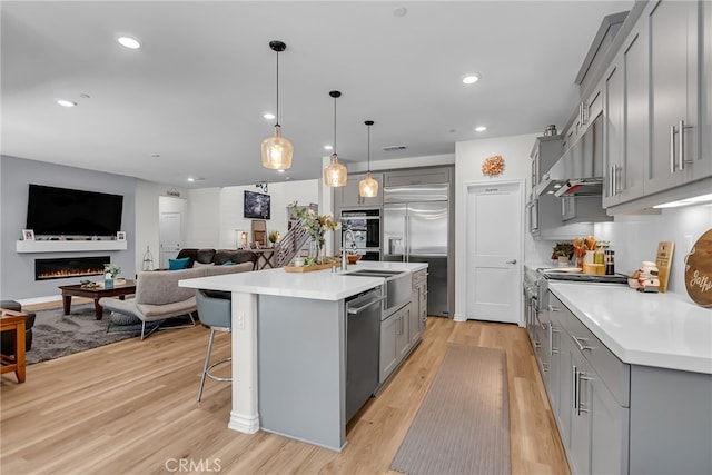 2760 Chad Zeller Ln, Corona, CA 92882 - kitchen featuring gray cabinetry, stainless steel appliances, under cabinet range hood, light wood-type flooring, and recessed lighting
