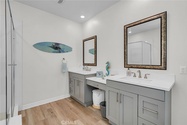 2760 Chad Zeller Ln, Corona, CA 92882 - bathroom with wood finished floors, two vanities, a shower with shower door, and baseboards