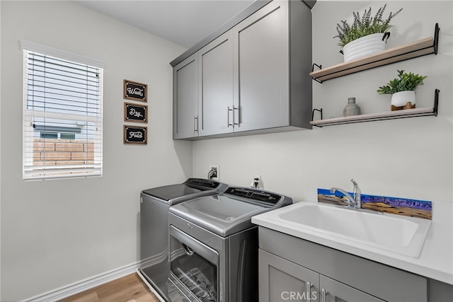 2760 Chad Zeller Ln, Corona, CA 92882 - washroom with cabinet space, washing machine and clothes dryer, baseboards, and light wood-style floors