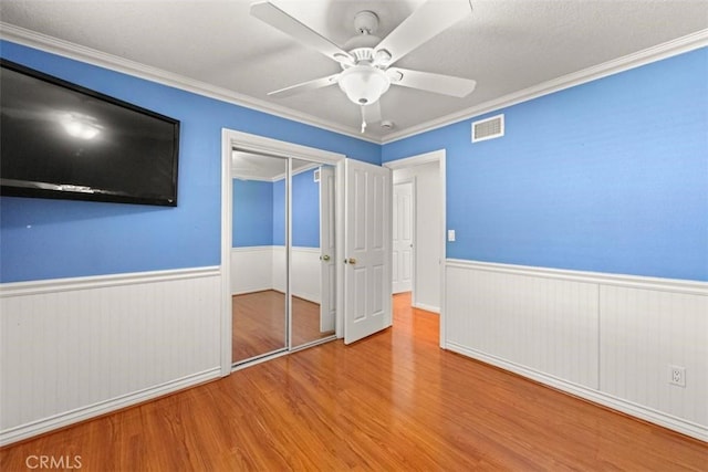 3275 Dalhart Ave, Simi Valley, CA 93063 - unfurnished bedroom featuring wood finished floors, wainscoting, a closet, crown molding, and a ceiling fan
