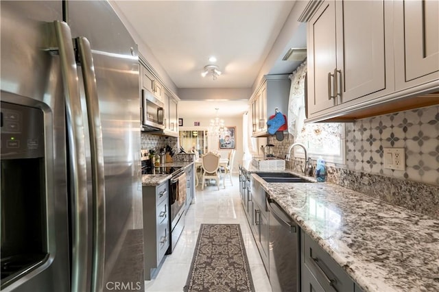 727 W Hill St, Long Beach, CA 90806 - kitchen with stainless steel appliances, gray cabinets, a sink, decorative backsplash, and light stone countertops