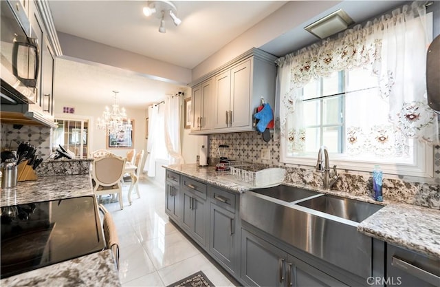 727 W Hill St, Long Beach, CA 90806 - kitchen featuring a chandelier, decorative backsplash, a sink, and gray cabinets