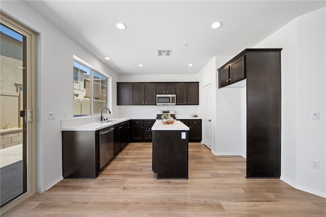 29562 Winterstorm Ct, Winchester, CA 92596 - kitchen with appliances with stainless steel finishes, a sink, a center island, light countertops, and light wood-style floors