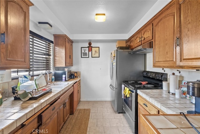 7614 Mason Ave, Winnetka, CA 91306 - kitchen featuring electric stove, tile countertops, under cabinet range hood, a sink, and brown cabinets