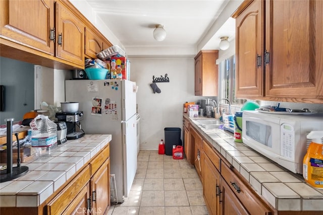 7614 Mason Ave, Winnetka, CA 91306 - kitchen featuring tile countertops, white appliances, a sink, and brown cabinets