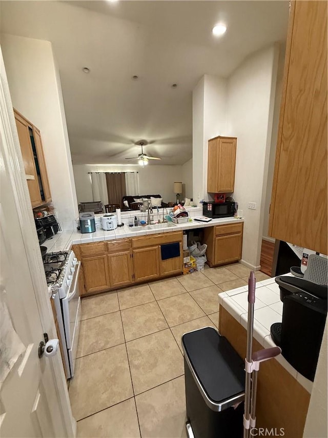 10333 Mendicino, Victorville, CA 92301 - kitchen with white gas stove, tile countertops, a sink, black microwave, and a peninsula