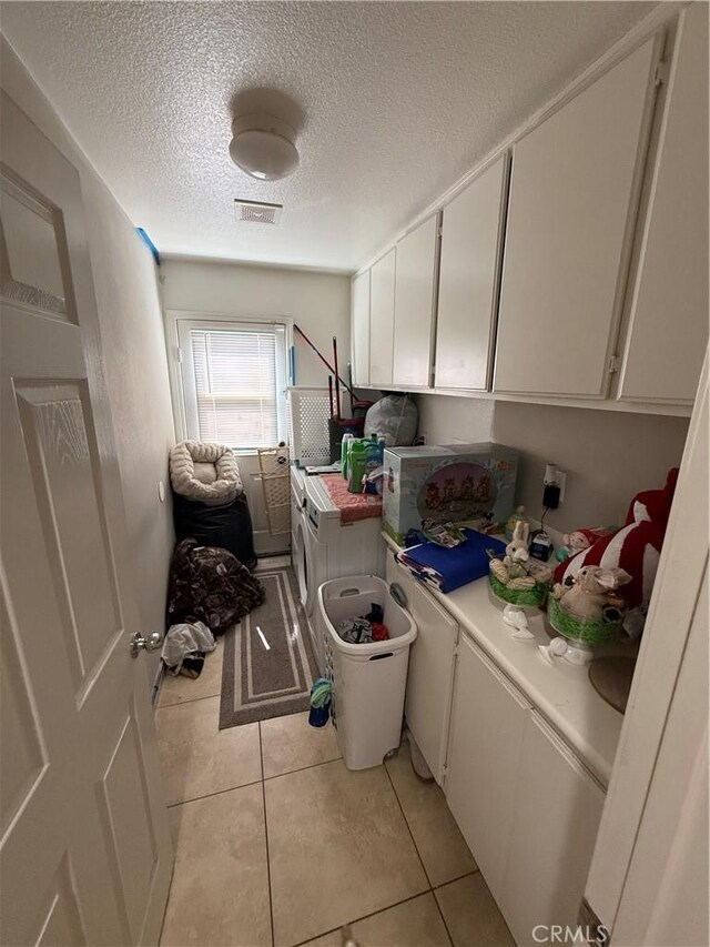 10333 Mendicino, Victorville, CA 92301 - laundry area with independent washer and dryer, cabinet space, a textured ceiling, and light tile patterned floors