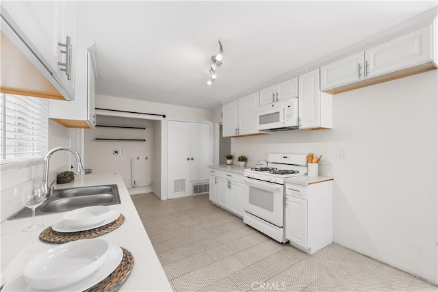 2398 Victoria St, San Bernardino, CA 92410 - kitchen featuring white appliances, a sink, white cabinetry, light countertops, and light tile patterned floors