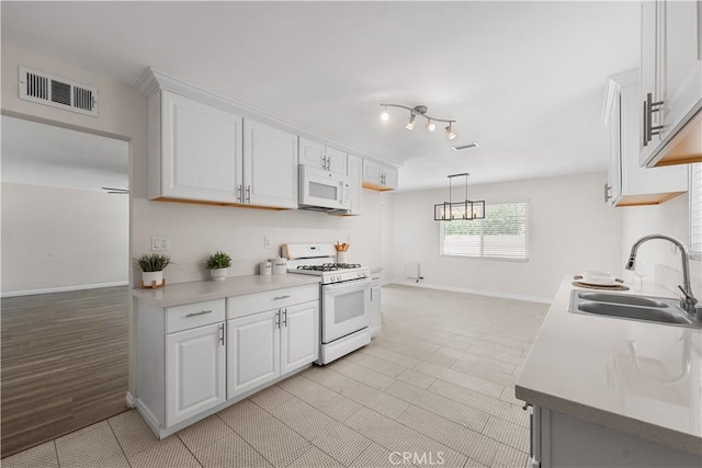 2398 Victoria St, San Bernardino, CA 92410 - kitchen with white appliances, a sink, white cabinets, light countertops, and baseboards
