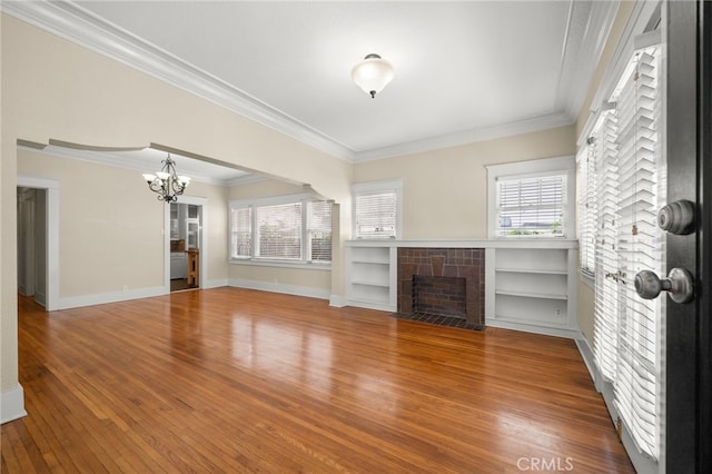 219 Redondo Ave, Long Beach, CA 90803 - unfurnished living room with a chandelier, wood finished floors, a tile fireplace, plenty of natural light, and ornamental molding