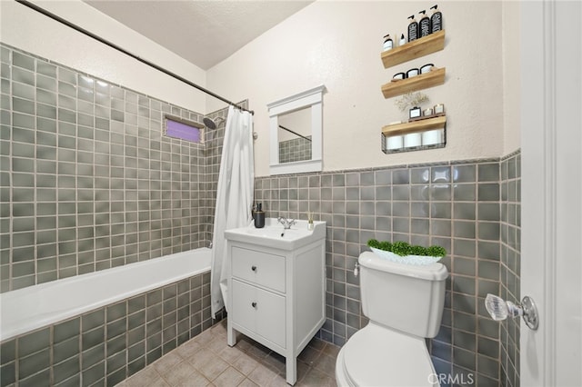 219 Redondo Ave, Long Beach, CA 90803 - full bathroom featuring tiled shower / bath combo, vanity, toilet, tile patterned floors, and tile walls