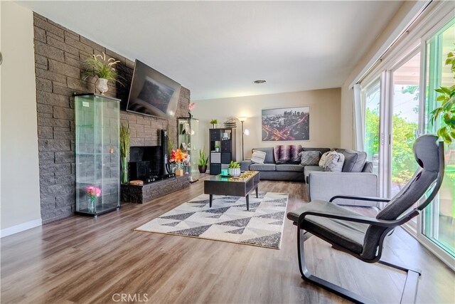 1016 N Marcella Ave, Rialto, CA 92376 - living room featuring wood finished floors, a brick fireplace, and baseboards