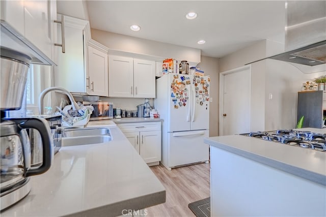 1016 N Marcella Ave, Rialto, CA 92376 - kitchen with white appliances, light countertops, white cabinets, light wood-style floors, and a sink