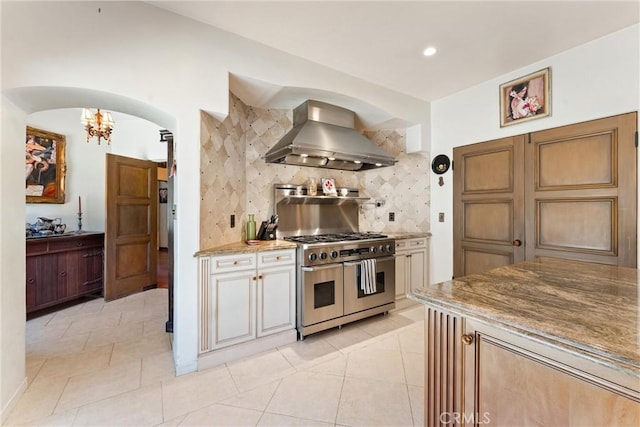 1422 Recado Rd, La Habra Heights, CA 90631 - kitchen with wall chimney exhaust hood, double oven range, arched walkways, backsplash, and a chandelier