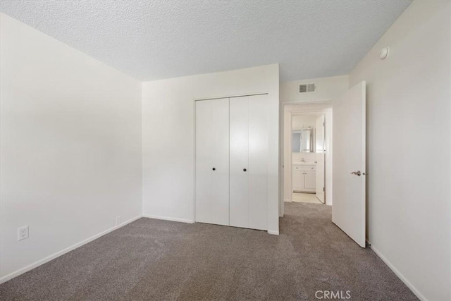 1750 Prefumo Canyon Rd Unit 17, San Luis Obispo, CA 93405 - unfurnished bedroom featuring carpet flooring, a closet, and a textured ceiling
