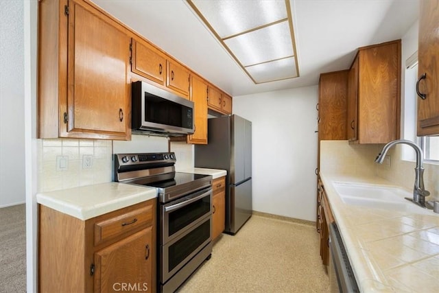1750 Prefumo Canyon Rd Unit 17, San Luis Obispo, CA 93405 - kitchen featuring stainless steel appliances, brown cabinetry, tasteful backsplash, light colored carpet, and tile counters