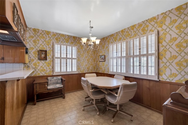 6130 Longridge Ave, Valley Glen, CA 91401 - dining space with a wainscoted wall, light flooring, wallpapered walls, a chandelier, and wood walls