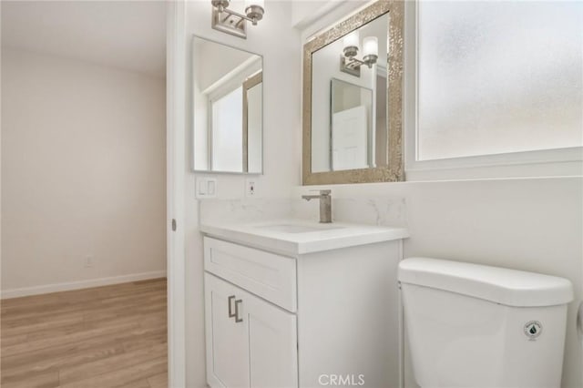 1304 N Devonshire Rd, Anaheim, CA 92801 - bathroom featuring vanity, toilet, wood finished floors, and baseboards