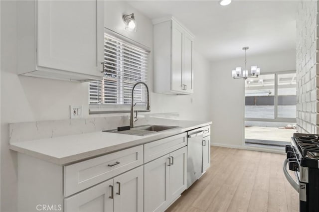 1304 N Devonshire Rd, Anaheim, CA 92801 - kitchen featuring a sink, stainless steel appliances, white cabinets, a chandelier, and light wood finished floors
