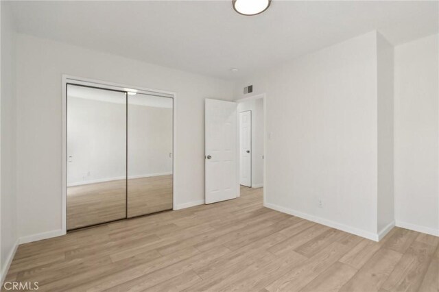 1304 N Devonshire Rd, Anaheim, CA 92801 - unfurnished bedroom with light wood-style flooring, baseboards, and a closet