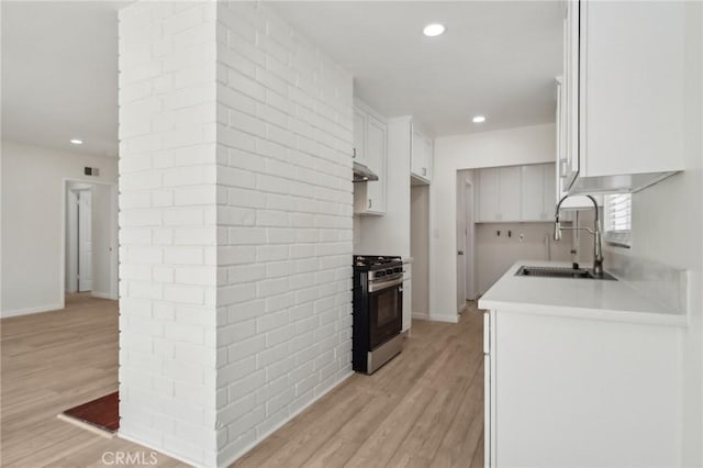 1304 N Devonshire Rd, Anaheim, CA 92801 - kitchen with gas stove, a sink, recessed lighting, white cabinetry, and light wood-style flooring