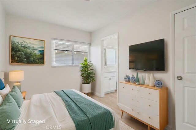 1304 N Devonshire Rd, Anaheim, CA 92801 - bedroom featuring light wood-style flooring, ensuite bath, and baseboards