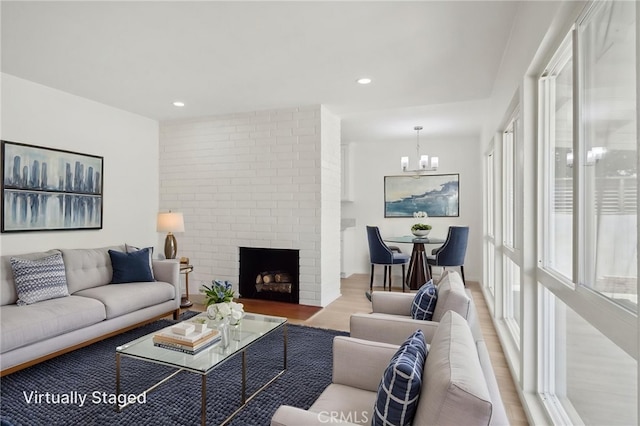 1304 N Devonshire Rd, Anaheim, CA 92801 - living area with a chandelier, wood finished floors, a brick fireplace, and recessed lighting