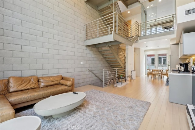 3450 Cahuenga Blvd W Unit 905, Los Angeles, CA 90068 - living room featuring stairs, light wood-style floors, and a towering ceiling