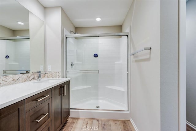 13139 Upland Ct, Hesperia, CA 92344 - bathroom featuring a shower stall, vanity, wood finished floors, and backsplash