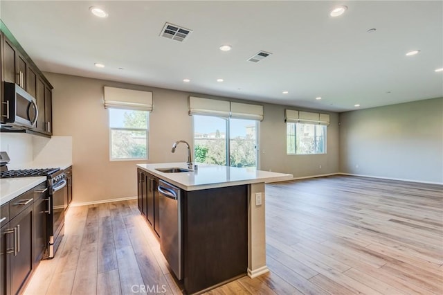 13139 Upland Ct, Hesperia, CA 92344 - kitchen with appliances with stainless steel finishes, a sink, light wood-style flooring, dark brown cabinetry, and recessed lighting