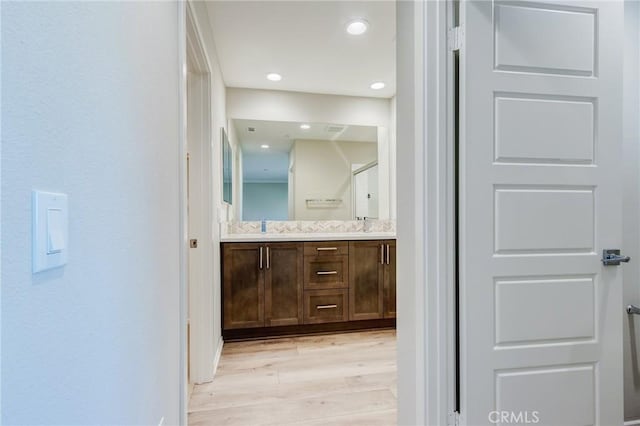 13139 Upland Ct, Hesperia, CA 92344 - bathroom featuring wood finished floors, double vanity, and a shower with shower door