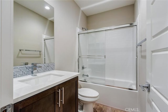 13139 Upland Ct, Hesperia, CA 92344 - full bathroom featuring vanity, wood finished floors, toilet, bath / shower combo with glass door, and backsplash