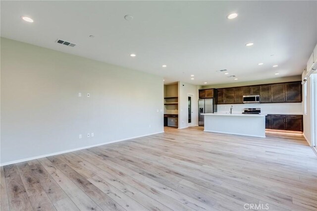 13139 Upland Ct, Hesperia, CA 92344 - unfurnished living room with light wood-style floors, recessed lighting, baseboards, and a sink