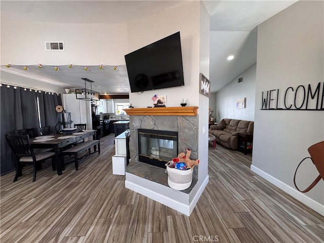 479 Stanford Dr, Barstow, CA 92311 - living room with wood finished floors, a fireplace, lofted ceiling, and baseboards