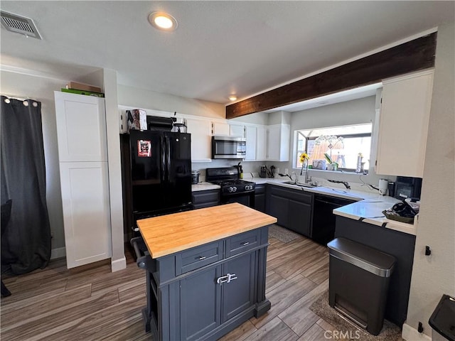 479 Stanford Dr, Barstow, CA 92311 - kitchen with black appliances, butcher block counters, a sink, white cabinets, and wood finished floors