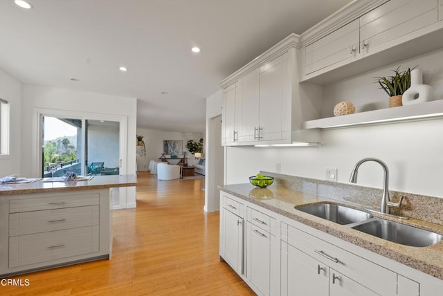 7560 Hollywood Blvd Unit 409, Los Angeles, CA 90046 - kitchen featuring a sink, light wood-style floors, open shelves, recessed lighting, and white cabinets