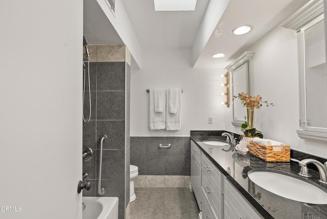 7560 Hollywood Blvd Unit 409, Los Angeles, CA 90046 - bathroom featuring tile walls, toilet, double vanity, tile patterned floors, and recessed lighting