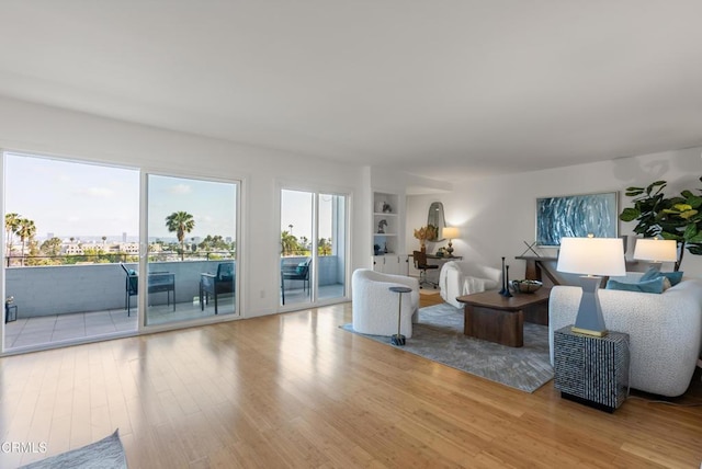 7560 Hollywood Blvd Unit 409, Los Angeles, CA 90046 - living room featuring wood finished floors, healthy amount of natural light, and built in shelves