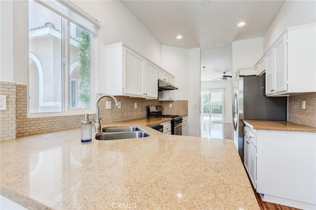 11259 Corsica Ct, Rancho Cucamonga, CA 91730 - kitchen with gas stove, under cabinet range hood, ceiling fan, white cabinets, and backsplash