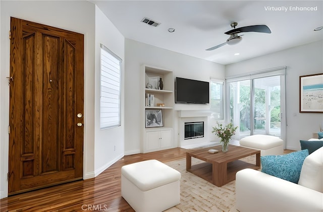 11259 Corsica Ct, Rancho Cucamonga, CA 91730 - living area with ceiling fan, wood finished floors, a glass covered fireplace, and built in features