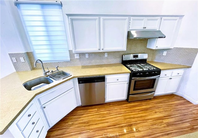 11259 Corsica Ct, Rancho Cucamonga, CA 91730 - kitchen with appliances with stainless steel finishes, under cabinet range hood, tasteful backsplash, light countertops, and white cabinetry