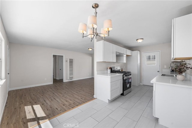 38881 Sage Tree St, Palmdale, CA 93551 - kitchen with gas range, a sink, light countertops, open floor plan, and white cabinetry